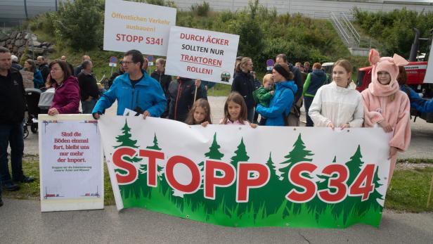 Demonstrierende mit Protestplakaten gegen die S34 und für den Ausbau des öffentlichen Verkehrs, einige Kinder vorn.