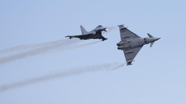 Zwei graue Eurofighter-Jets fliegen am Himmel und hinterlassen Rauchstreifen.
