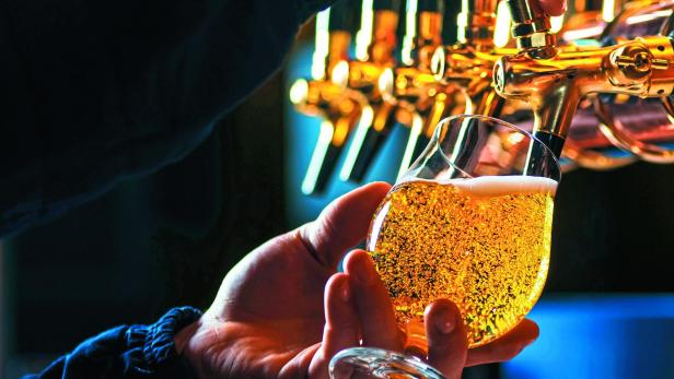 Close up of bartender pouring draft beer in glass