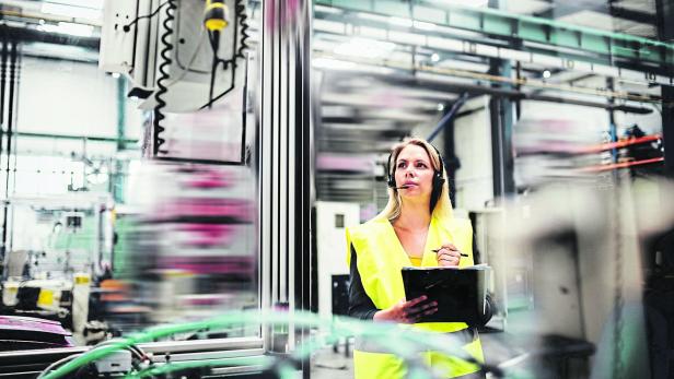 Industrial woman engineer with headset in a factory, working. Copy space.