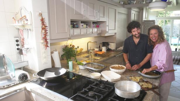 Ein Mann und eine Frau bereiten gemeinsam Speisen in einer Küche zu.