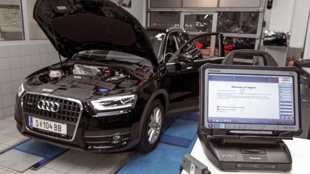 Ein schwarzer Audi Q3 steht mit geöffneter Motorhaube in einer Werkstatt zur Diagnose bereit.
