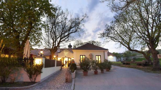 Das erleuchtete Restaurant „Kloster Und Thalhof“ in der Abenddämmerung.