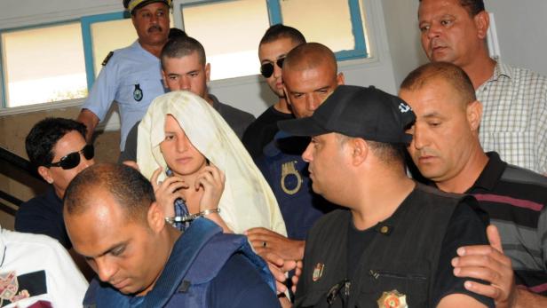 epa03732709 Amina Sboui (C), the Tunisian member of the Ukrainian feminist group FEMEN, appears handcuffed before an investigating judge at the courthouse of the central city of Kairouan, Tunisia, 05 June 2013. A Tunisian court on 05 June ordered the continued detention of three European women arrested last week over a topless protest outside the Justice Ministry. EPA/STR