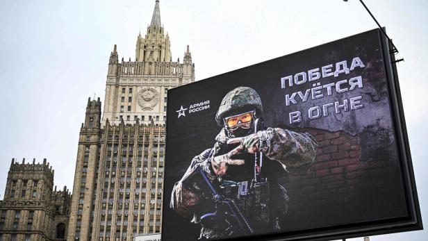 Ein Werbeplakat der russischen Armee vor dem Außenministerium in Moskau zeigt einen Soldaten mit dem Slogan „Der Sieg wird im Feuer geschmiedet“.