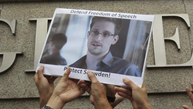 Protesters supporting Edward Snowden, a contractor at the National Security Agency (NSA), hold a photo of Snowden during a demonstration outside the U.S. Consulate in Hong Kong June 13, 2013. China&#039;s Foreign Ministry offered no details on Thursday on Snowden, the National Security Agency contractor who revealed the U.S. government&#039;s top-secret monitoring of phone and Internet data and who is in hiding in Hong Kong. REUTERS/Bobby Yip (CHINA - Tags: POLITICS SCIENCE TECHNOLOGY CIVIL UNREST TPX IMAGES OF THE DAY)
