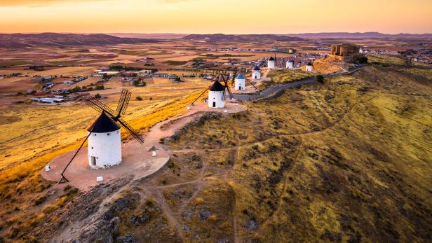 Windmühlen auf einem Hügel in Consuegra, Spanien, bei Sonnenuntergang.