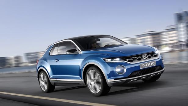 Ein blauer VW T-Roc fährt auf einer Straße in der Stadt.