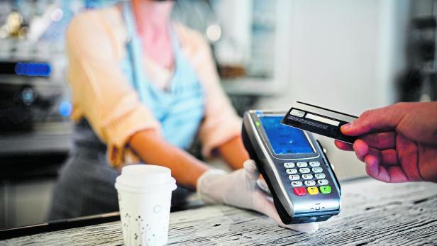 Contactless payment with debit card, coffee shop open after lockdown.