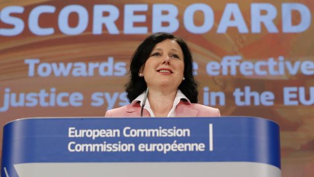 Eine Frau spricht vor einem Schild der Europäischen Kommission.