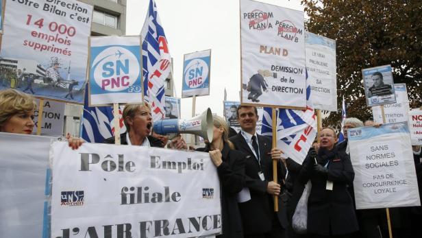 Demonstranten protestieren gegen den Stellenabbau bei Air France mit Schildern und Megaphonen.