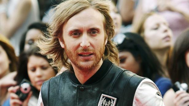 David Guetta auf einem Event mit Fans im Hintergrund.