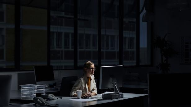 Businesswoman using computer in dark office