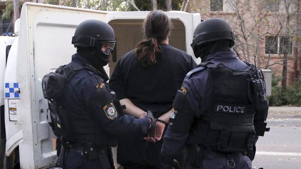 Handout shows police officers detaining a man duri Polizisten nehmen einen Verdächtigen fest.