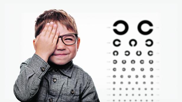 little boy having eye exam with eye chart