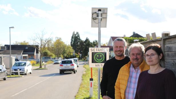 Stadtrat Peter Molnar (SPÖ), GR Alfred Scheichel (SPÖ) und Kerstin Wegenberger (Amt für Stadt- und Verkehrsplanung) vor dem Messgerät in der Langenloiser Straße.