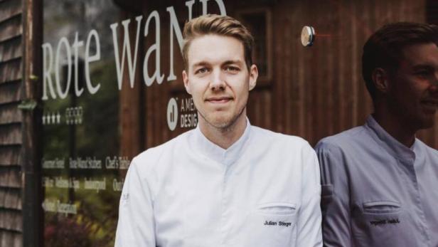 Julian Stieger, Küchenchef im Hotel Rote Wand, posiert vor dem Hoteleingang.