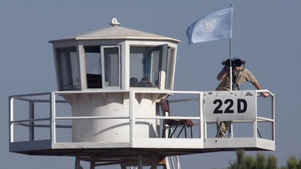 A member of the U.N. peacekeeping force known as UNDOF (United Nations Disengagement Observer Force) watches as Druze villagers make their way to Syria at the Quneitra crossing in the Golan Heights September 24, 2009. Every year Israel allows Druze religious figures to visit holy graves and relatives in Syria. This year, women joined the 5-day trip for the first time. REUTERS/Ancho Gosh/Jini (ISRAEL RELIGION POLITICS)