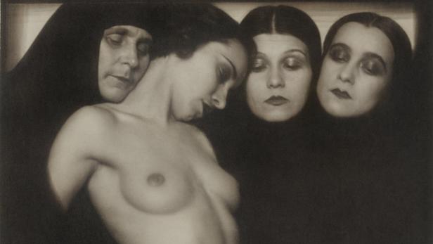 Eine Aktaufnahme einer Frau, umgeben von drei weiteren Frauen mit dunklen Schleiern.