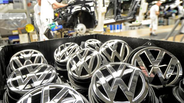 Ein Behälter voller VW-Logos in einer Automobilfabrik.