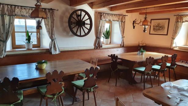 Ein traditionell eingerichtetes Restaurant mit Holztischen und Stühlen.