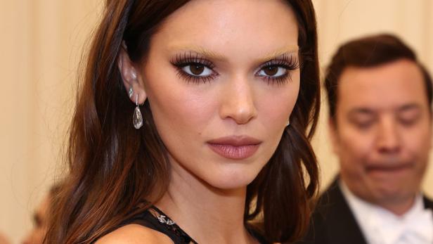 Kendall Jenner mit blonden Augenbrauen und einem transparenten schwarzen Oberteil.