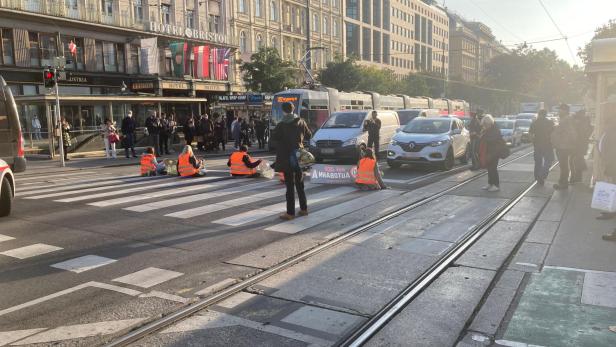 Aktivisten blockieren eine Straßenbahnhaltestelle in Wien vor dem Hotel Bristol.
