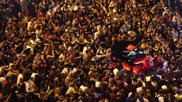 German pianist Davide Martello is surrounded by anti-government protesters as he performs in Istanbul&#039;s Taksim square June 13, 2013. Turkish Prime Minister Tayyip Erdogan met members of a group opposed to the redevelopment of an Istanbul park on Thursday in what appeared to be a final bid to end two weeks of anti-government protests through negotiation. REUTERS/Yannis Behrakis (TURKEY - Tags: CIVIL UNREST POLITICS TPX IMAGES OF THE DAY)