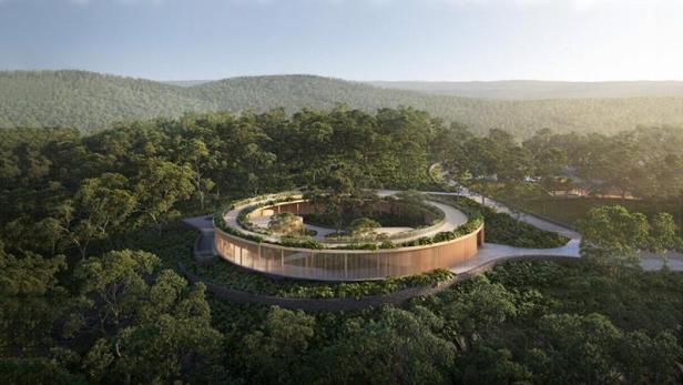 Ein rundes Gebäude mit Innenhof inmitten eines dichten Waldes.