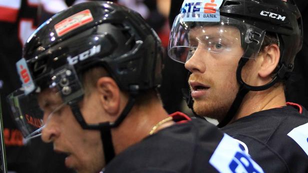 Zwei Eishockeyspieler mit Helmen und Visieren auf dem Eis.