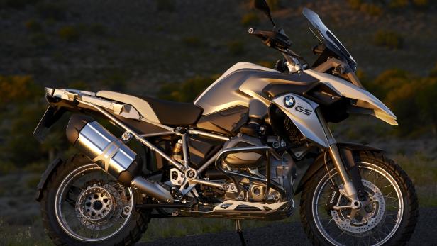 Eine silberne BMW GS Enduro steht auf einer asphaltierten Straße.