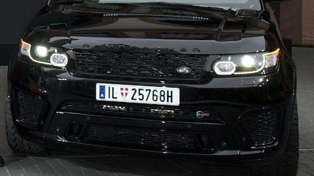 Die Frontansicht eines schwarzen Range Rover SVR mit eingeschalteten Scheinwerfern.