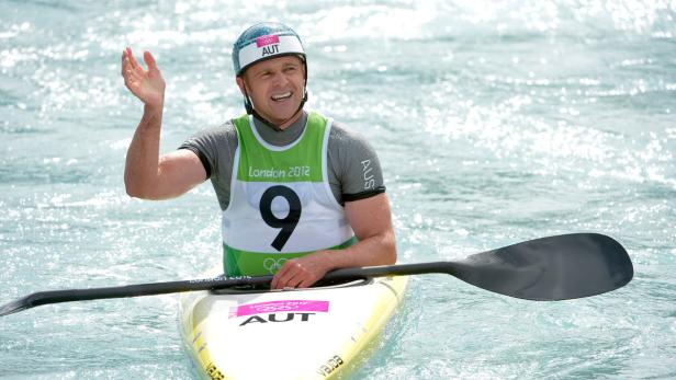 Ein österreichischer Kanute winkt in seinem Kajak während eines Wettkampfs.