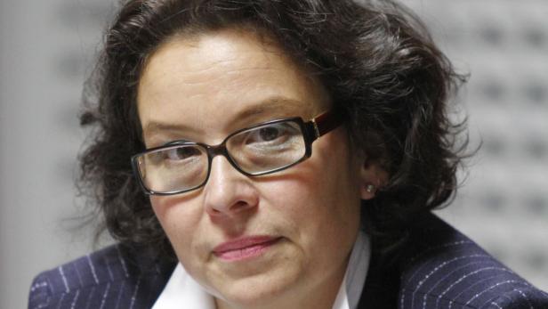 Eine Frau mit dunklen Haaren und Brille blickt in die Kamera.