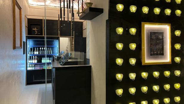 Innenansicht eines modernen Restaurants mit einer Bar und einer Wand mit dekorativen Lichtern.