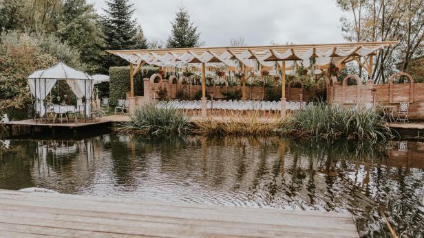 Ein Veranstaltungsort am Wasser mit einem Pavillon und Stuhlreihen für eine Zeremonie.