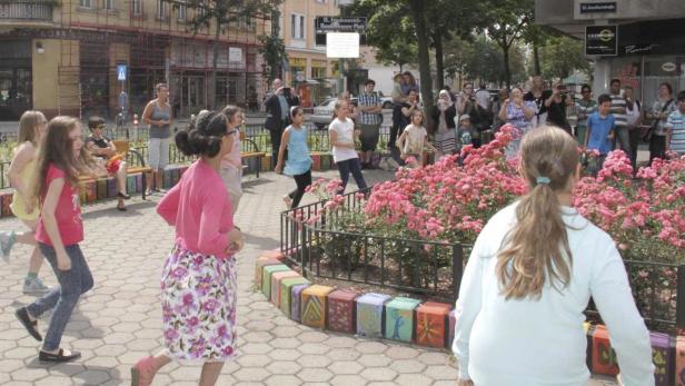 Eine Gruppe von Kindern spielt auf dem H. Friedensreich Hundertwasser-Platz.