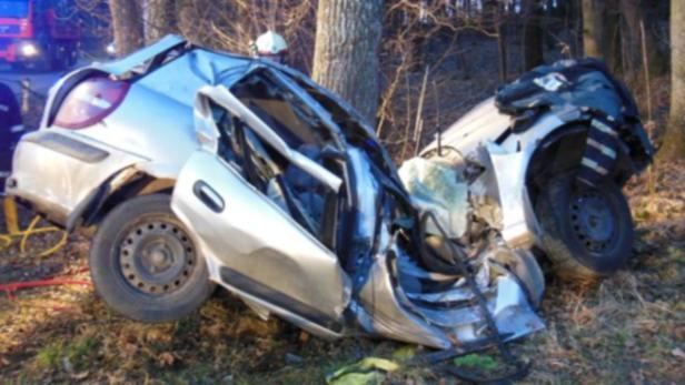 Ein silbernes Auto ist bei einem Unfall gegen einen Baum gefahren und stark beschädigt worden.