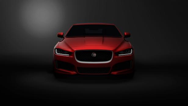 Ein roter Jaguar XE vor einem dunklen Hintergrund.