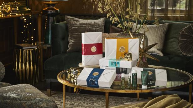 Geschenksets von Rituals stehen auf einem goldenen Tisch in einem Wohnzimmer.
