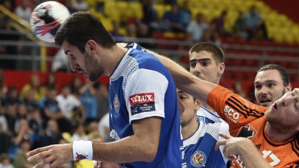 Ein Handballspieler im blauen Trikot versucht, den Ball zu fangen.