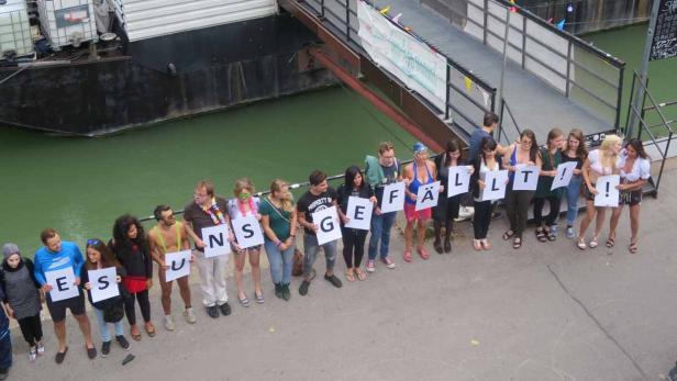 Eine Gruppe von Menschen hält Schilder mit der Aufschrift „Es gefällt!“.
