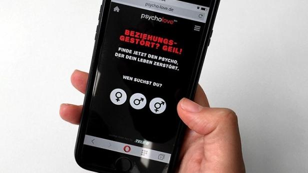 Eine Hand hält ein Smartphone mit der Webseite „psycholove.de“.