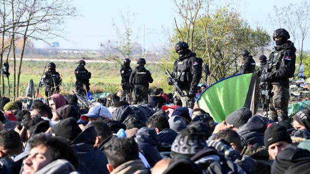 Serbische Polizisten bewachen Migranten in der Nähe der ungarischen Grenze