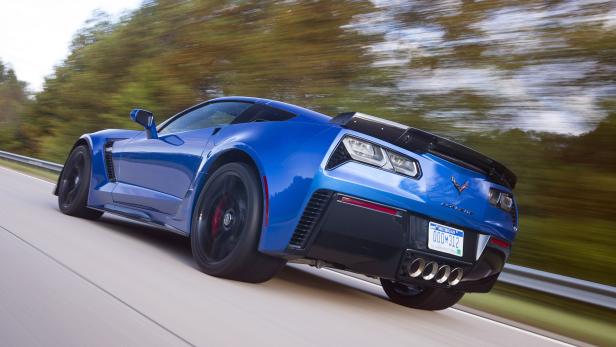 Eine blaue Corvette fährt auf einer Landstraße.