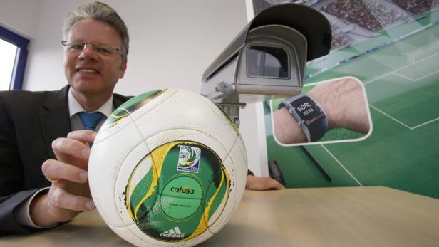 Dirk Broichhausen, managing director of Goal Control poses behind a goal control camera and the official ball for the 2014 FIFA World Cup Brazil in Wuerselen near the western German city of Aachen April 8, 2014. The German firm Goal Control has been appointed by the FIFA as the official provider for the goal-line technology (GLT) at the Confederations Cuip 2013.Goal Control is also set to be GLT provider for the World Cup 2014 provided that the performance of the system during this year&#039;s Festival of Champions meets all necessary FIFA requirements. REUTERS/Wolfgang Rattay (GERMANY - Tags: CRIME LAW CIVIL UNREST)