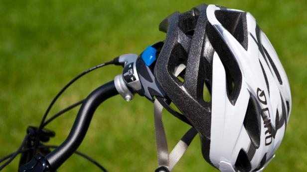 Ein Fahrradhelm der Marke Giro hängt am Lenker eines Fahrrads.