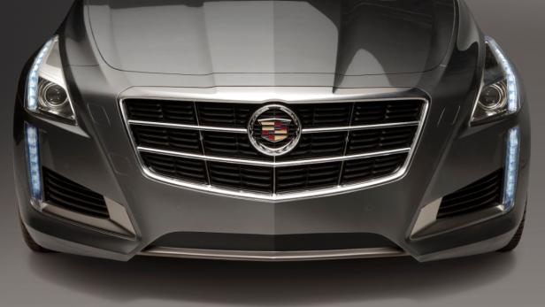 Nahaufnahme der Frontpartie eines grauen Cadillac mit Kühlergrill und Scheinwerfern.