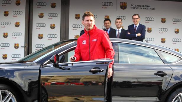 Lionel Messi steigt in einen schwarzen Audi, im Hintergrund Sponsorenlogos von Audi und FC Barcelona.