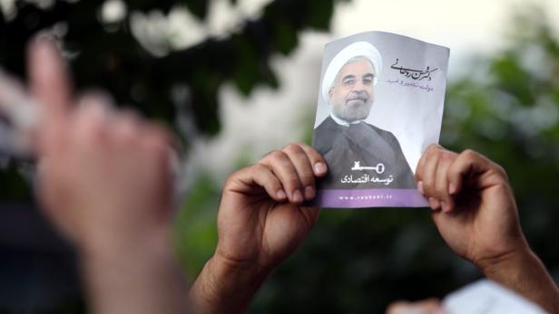 epa03746456 A supporter of newly elected President Hassan Rowhani as holds a poster depicting him during street festivities after the official announcement of his victory, in Tehran, Iran, 15 June 2013. Reformist candidate Hassan Rouhani has won Iran&#039;s presidential election with more than 50 per cent of votes, Interior Minister Mohammad Mostafa Najar announced. Rouhani outclassed the other five candidates, especially the two close to the establishment: Hardliner Saeid Jalili and conservative Ali-Akbar Velayati. Turnout in Friday&#039;s vote was 72 per cent. Observers had said that in case of a high turnout, Rouhani would also benefit from protest votes. EPA/ABEDIN TAHERKENAREH